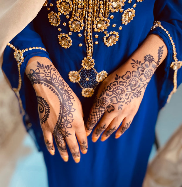 Woman's hand up to her wrist, adorned with Jagua paste in a dainty design created using Amarya Henna Jagua cones.