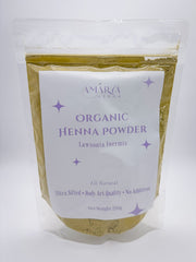 A sealed, clear resealable pouch of Amarya Henna Organic Henna Powder with a white and purple label. The label reads "Amarya Henna," "Organic Henna Powder," "Lawsonia Inermis," and highlights features such as "All Natural," "Ultra Sifted," "Body Art Quality," and "No Additives." The net weight is 250g.