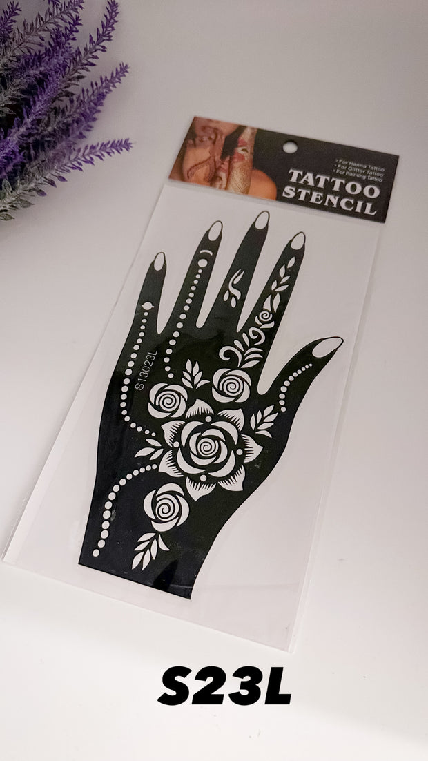 A black hand stencil with floral and geometric patterns, labeled as 'S23L', packaged on a clear plastic sheet with a cardboard backing.