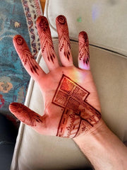 Woman hand palm with intricate symmetrical henna designs applied using Amarya Henna cones.