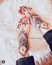 Fair light-skinned woman feet adorned with an intricate Jagua design, showcasing a deep blue-black stain created using Amarya Henna Jagua cones.